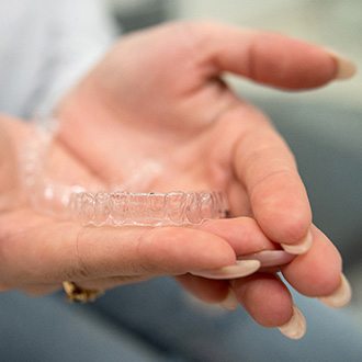 Closeup of patient holding clear aligner