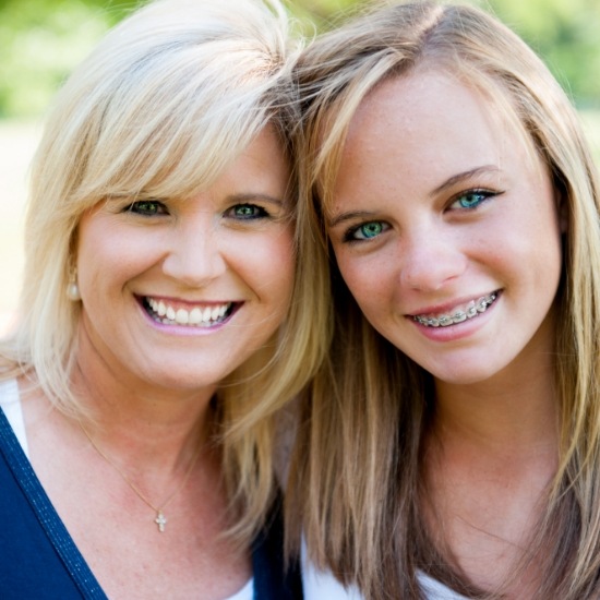Teenage girl with braces smiling with her mother