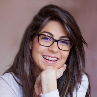 Woman with glasses and braces smiling