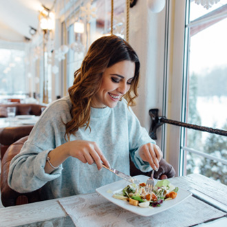 Woman smiling while eating at restaurant