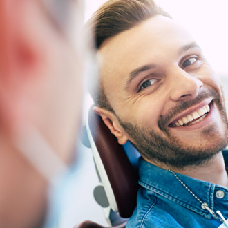 Man smiling while looking at dentist
