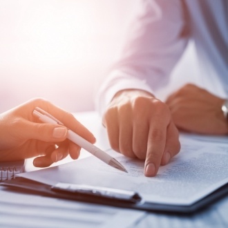 Two people looking at a paper on a clipboard