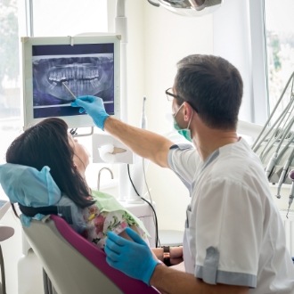 Orthodontist showing a patient x rays of their teeth