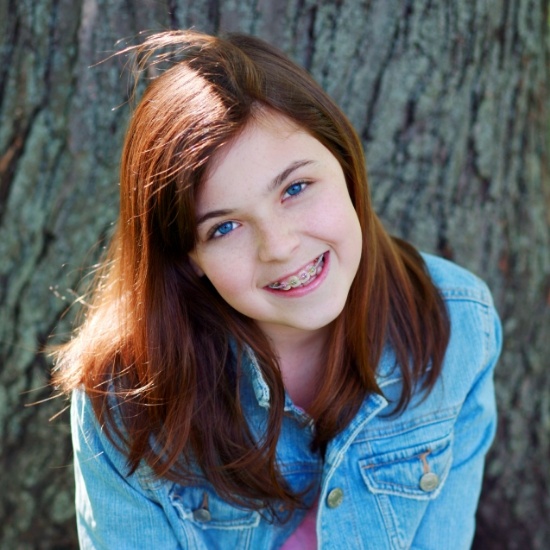 Teenage girl with braces smiling after orthodontic services in Wayland