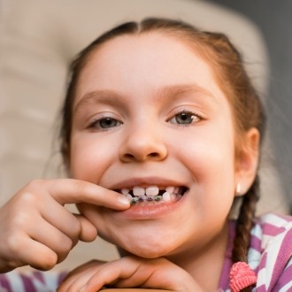 Young girl pointing to her braces