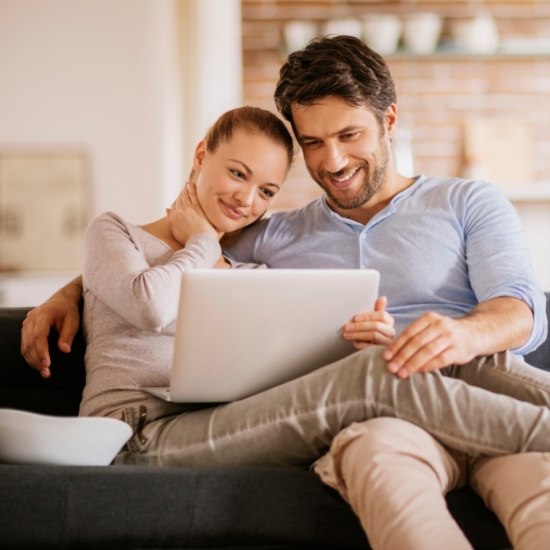 Man and woman looking at laptop for orthodontist reviews in Wayland
