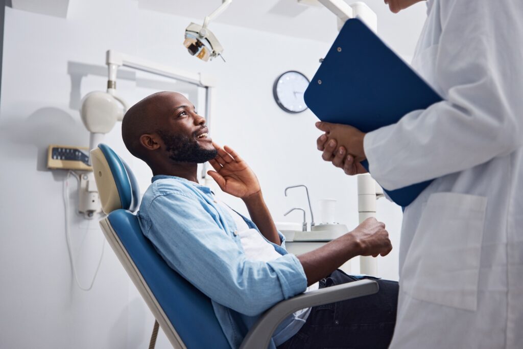 Patient talking to dentist holding clipboard